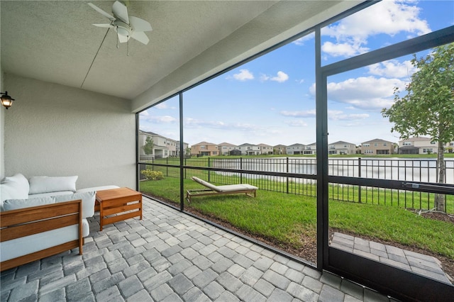 sunroom with a water view and ceiling fan