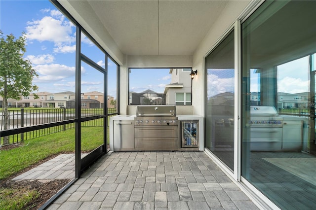 sunroom featuring a water view and wine cooler