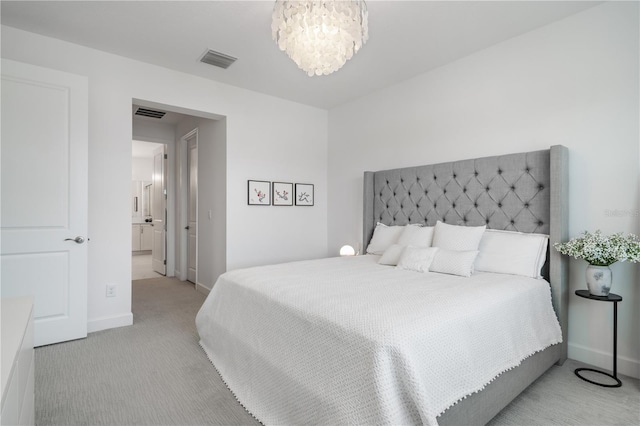 carpeted bedroom with ensuite bathroom and a notable chandelier