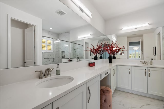 bathroom with double vanity, an enclosed shower, and tile patterned flooring