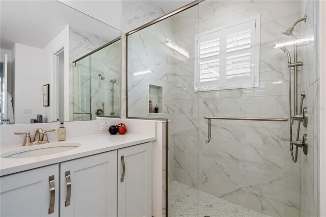 bathroom with a shower with shower door and vanity