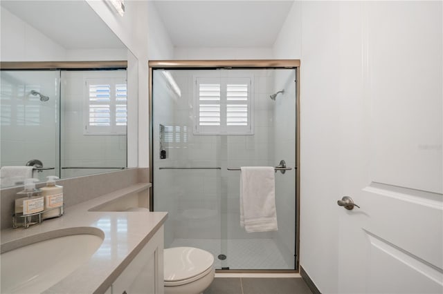 bathroom with tile patterned flooring, vanity, toilet, and plenty of natural light