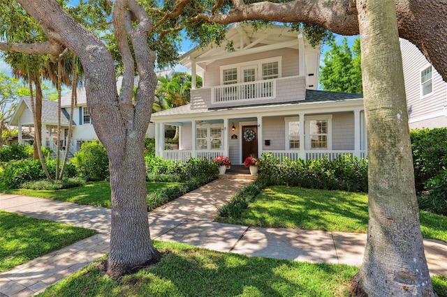 106 19th Ave, St Pete Beach, FL 33706 - view of front of property with a porch, a front lawn, and a shingled roof