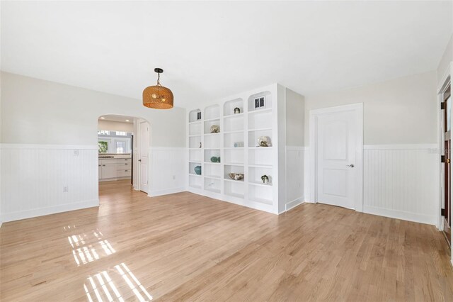 106 19th Ave, St Pete Beach, FL 33706 - spare room with arched walkways, wainscoting, and light wood-style floors