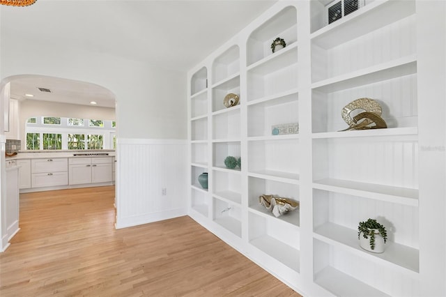 106 19th Ave, St Pete Beach, FL 33706 - hall featuring arched walkways, wainscoting, and light wood-style floors