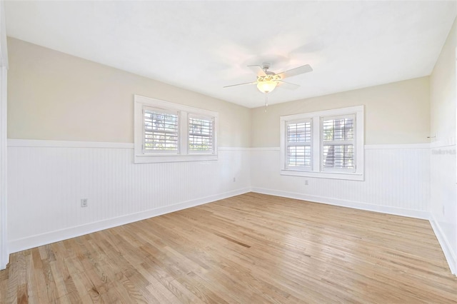 106 19th Ave, St Pete Beach, FL 33706 - unfurnished room with a wainscoted wall, light wood-style floors, and a ceiling fan