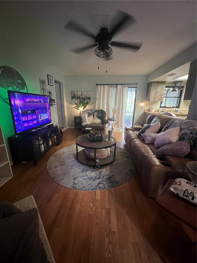 living room featuring wood-type flooring and ceiling fan