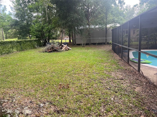 view of yard featuring a fenced in pool and glass enclosure