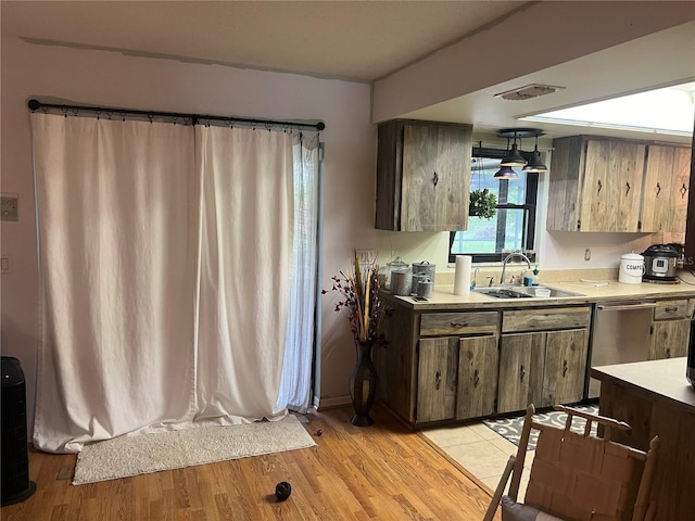 kitchen with dishwasher, light hardwood / wood-style floors, and sink