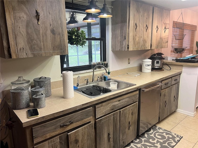 kitchen featuring hanging light fixtures, light tile patterned floors, dark brown cabinets, stainless steel dishwasher, and sink