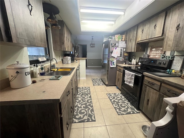 kitchen with black electric range oven, light tile patterned floors, sink, and stainless steel fridge