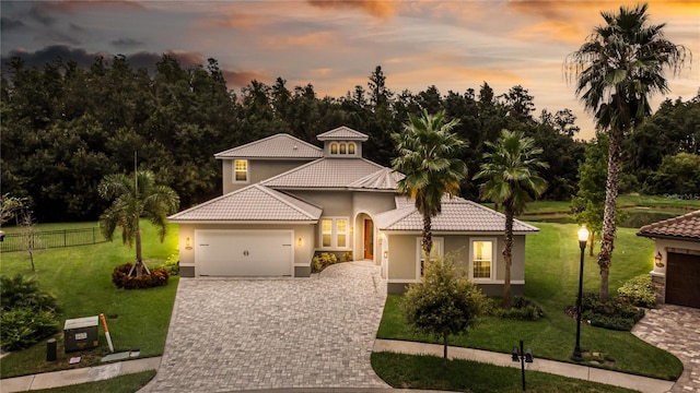 mediterranean / spanish home featuring a lawn and a garage