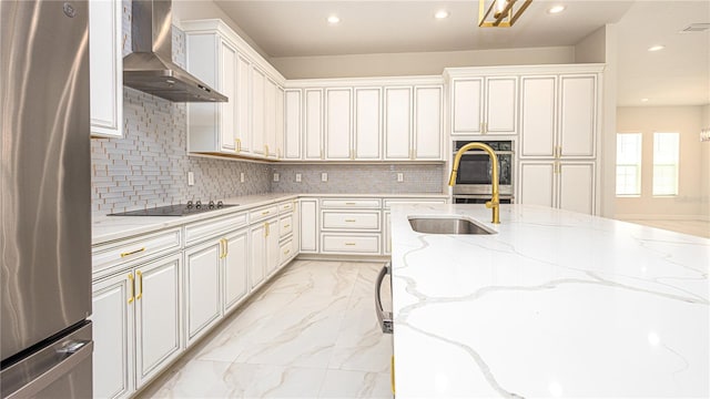 kitchen with stainless steel appliances, light stone countertops, light tile patterned flooring, backsplash, and wall chimney range hood