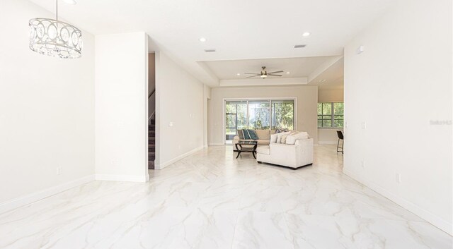 living room with ceiling fan, light tile patterned flooring, and a raised ceiling