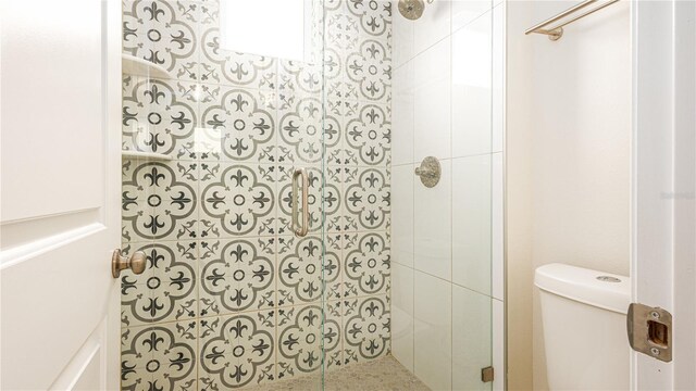 bathroom featuring a tile shower and toilet