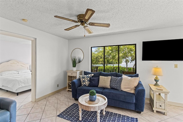 living room featuring a textured ceiling, ceiling fan, and light tile patterned floors