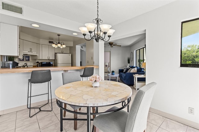 dining space featuring ceiling fan with notable chandelier and light tile patterned floors