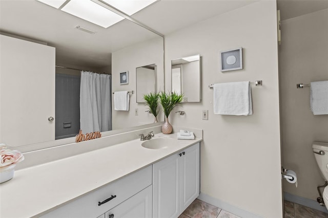 bathroom featuring tile patterned flooring, toilet, and vanity