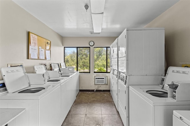 common laundry area with a wall unit AC, washer and clothes dryer, stacked washer / drying machine, and light tile patterned flooring