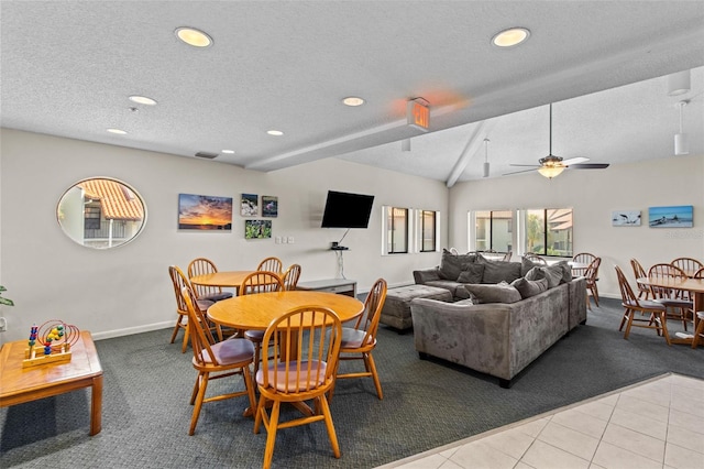 dining space with ceiling fan, light tile patterned floors, lofted ceiling with beams, and a textured ceiling