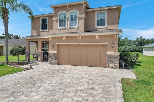 116 Caladium Ct, Bradenton, FL 34212 - view of front of house with stucco siding, stone siding, a front lawn, a garage, and decorative driveway