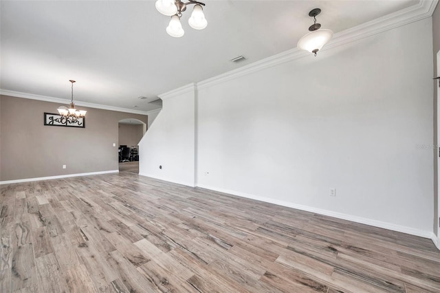 unfurnished living room with ornamental molding, light wood-type flooring, and a chandelier