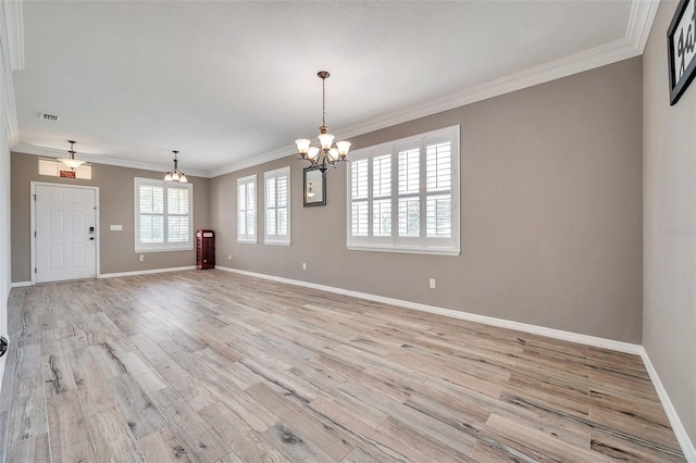 unfurnished room featuring an inviting chandelier, light wood-type flooring, and crown molding