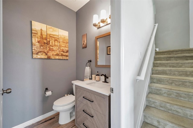 bathroom with hardwood / wood-style floors, vanity, and toilet