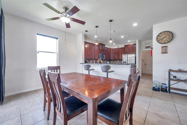 dining area featuring ceiling fan, light tile patterned flooring, and sink