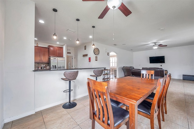 tiled dining room featuring ceiling fan and sink