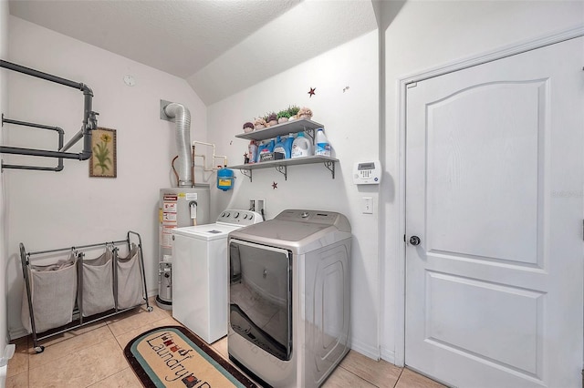 laundry area with a textured ceiling, washer and clothes dryer, gas water heater, and light tile patterned floors