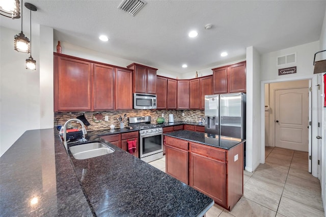 kitchen featuring appliances with stainless steel finishes, tasteful backsplash, a textured ceiling, dark stone counters, and sink