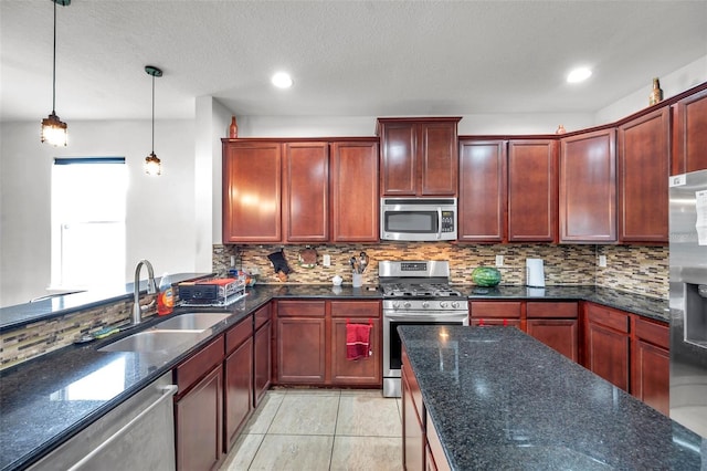 kitchen with appliances with stainless steel finishes, backsplash, sink, and decorative light fixtures