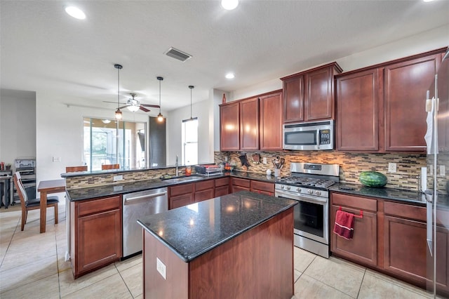 kitchen with ceiling fan, sink, kitchen peninsula, decorative light fixtures, and stainless steel appliances