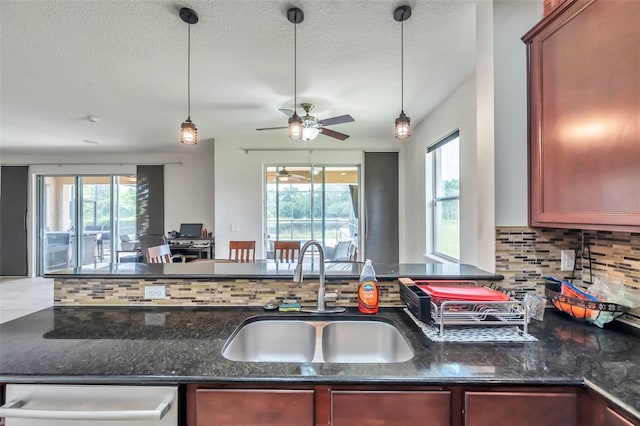 116 Caladium Ct, Bradenton, FL 34212 - kitchen featuring a sink, backsplash, open floor plan, dark stone countertops, and decorative light fixtures
