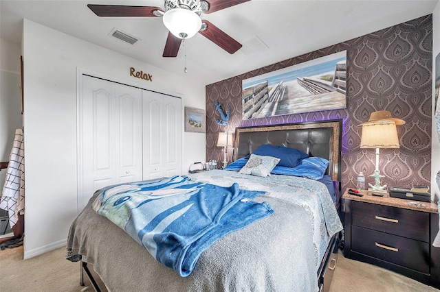 bedroom with ceiling fan, a closet, and light carpet