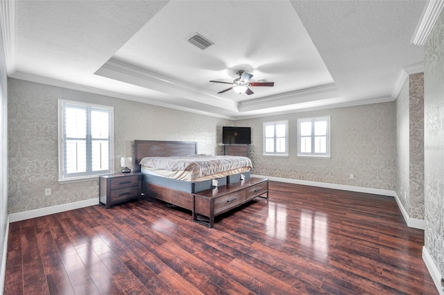 unfurnished bedroom with ceiling fan, ornamental molding, a tray ceiling, and dark wood-type flooring