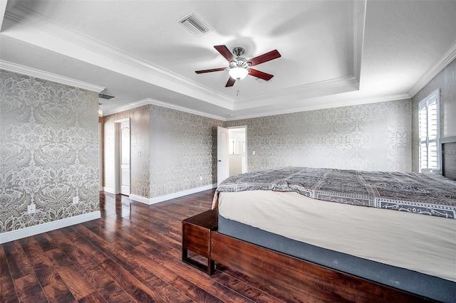 bedroom with crown molding, a tray ceiling, ceiling fan, and dark wood-type flooring