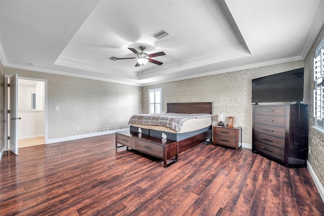 bedroom with ornamental molding, a tray ceiling, ceiling fan, and dark wood-type flooring