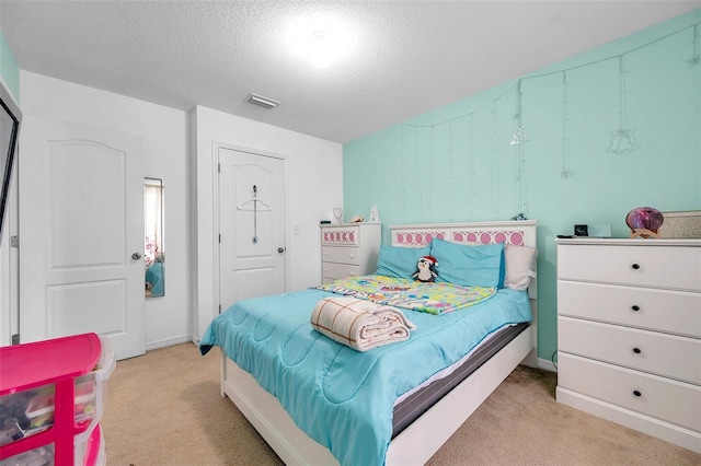 bedroom featuring light colored carpet and a textured ceiling