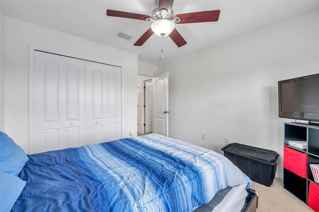 carpeted bedroom featuring ceiling fan and a closet