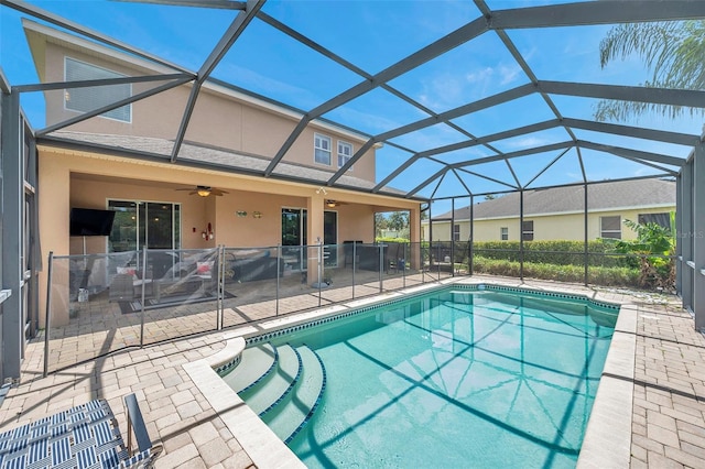 view of pool with glass enclosure, ceiling fan, and a patio area