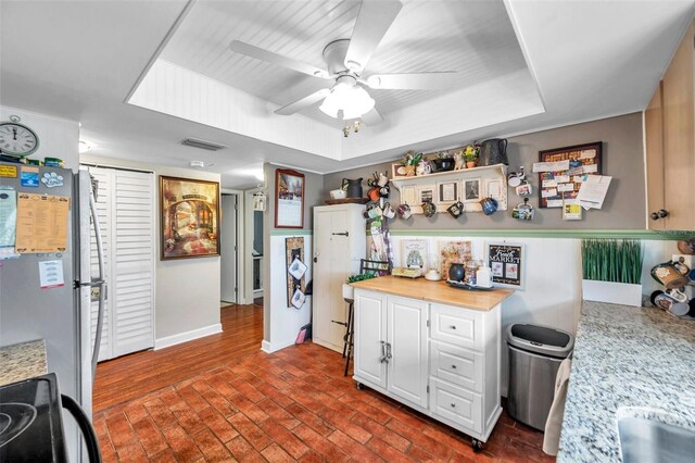 kitchen featuring sink, range, white cabinets, stainless steel fridge, and ceiling fan