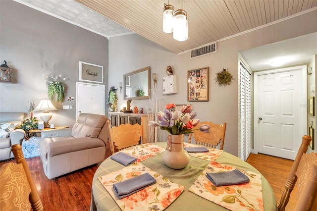 dining area featuring hardwood / wood-style flooring and ornamental molding