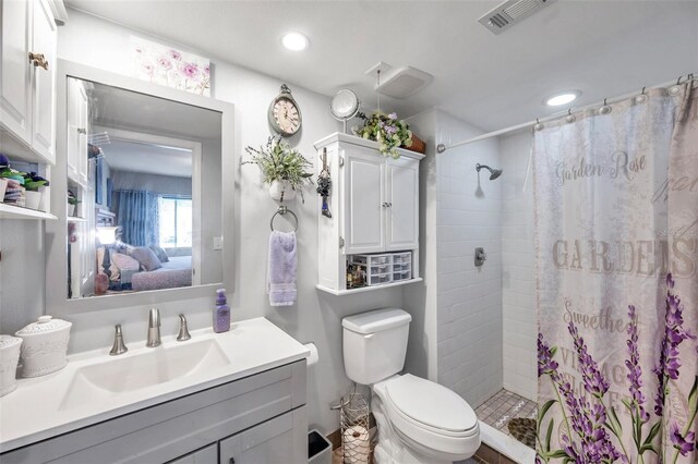 bathroom featuring toilet, vanity, and a shower with curtain