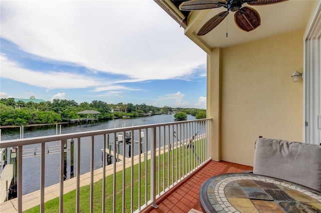 balcony featuring ceiling fan and a water view