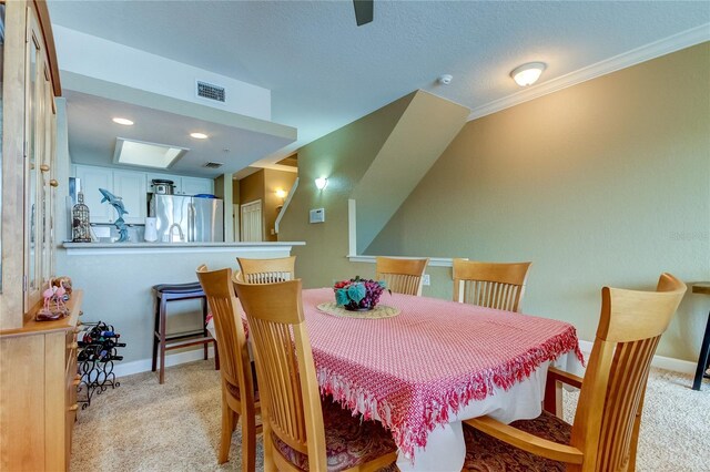 dining space with a textured ceiling and light colored carpet