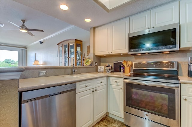 kitchen featuring appliances with stainless steel finishes, ornamental molding, white cabinetry, and ceiling fan