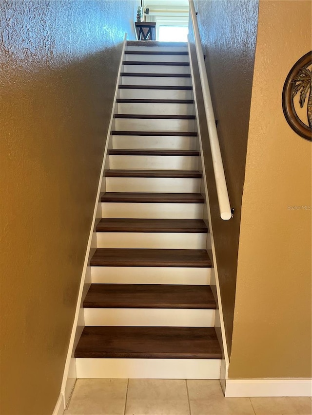 stairway with tile patterned floors