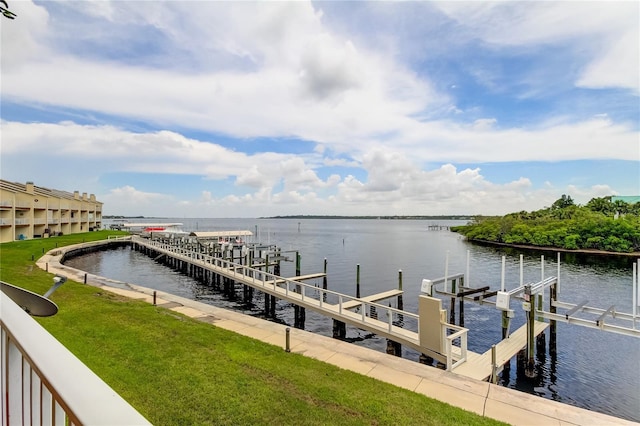 view of dock with a water view and a yard